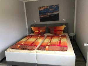 een wit bed met 2 kussens in een kamer bij Ferienwohnung Lorenz in Korswandt