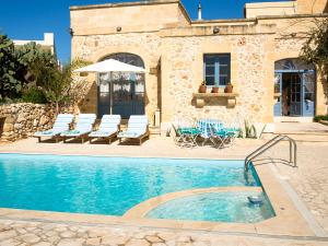 uma villa com piscina em frente a uma casa em L'Gharix Temple Retreat em Xaghra