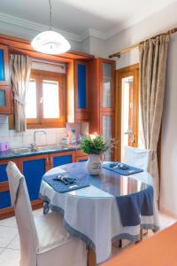 een keuken met een tafel met een blauwe tafeldoek bij Athena's Luxury Place in Agria