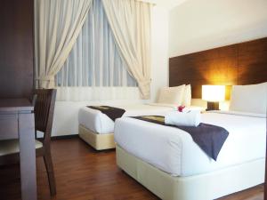 a hotel room with two beds and a desk at Samsuria Beach Apartment Resort in Cherating