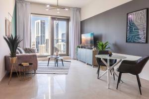 a living room with a couch and a table at Stella Stays Stylish 1 BDR Dubai JBR Beach Netflix in Dubai