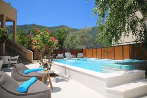 a swimming pool with chairs and a table and a table at Apartments Jovanovic - Alkima in Kotor