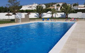 uma grande piscina com água azul num resort em Parque de Campismo Orbitur Valverde na Praia da Luz