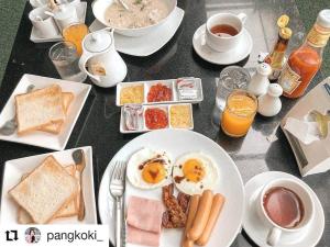 a table topped with plates of breakfast foods and coffee at Manita Boutique Hotel in Pattaya South