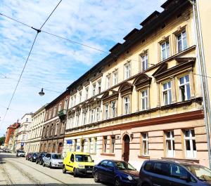 a building with cars parked on the side of a street at Krakart Apartment in Krakow