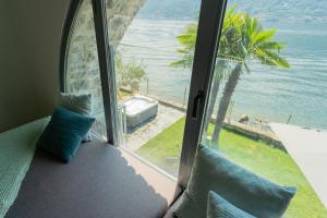a room with a window looking out at the ocean at Villa Sasso on Lake Como by Rent All Como in Sala Comacina