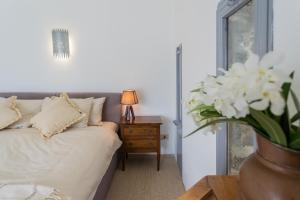 a bedroom with a bed and a table with a vase of flowers at Villa Sasso on Lake Como by Rent All Como in Sala Comacina