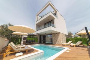 eine Villa mit einem Pool und einem Haus in der Unterkunft Luxury Villa Favela with heated pool in Trogir