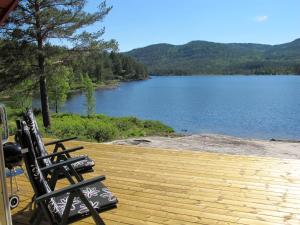 twee stoelen op een terras met uitzicht op een meer bij Chalet Risdalbu - SOO021 by Interhome in Mjåvatn