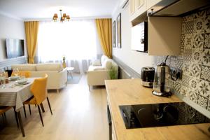 a kitchen and living room with a table and chairs at Central Boutique Apartments in Sighişoara