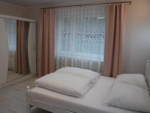 białe łóżko w pokoju z oknem w obiekcie APARTAMENT Magurka w mieście Rycerka Górna