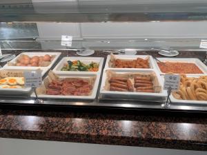 a buffet with different types of food in trays at Aparthotel Los Dragos del Sur in Puerto de Santiago