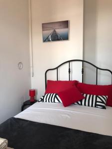 1 dormitorio con 1 cama con almohadas rojas y negras en STUDIO APARTMANI PAOLA en Rijeka