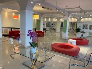 a lobby with red chairs and a vase with purple flowers at Aparthotel Los Dragos del Sur in Puerto de Santiago