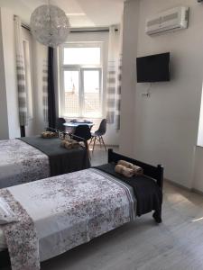 1 dormitorio con 2 camas, mesa y TV en STUDIO APARTMANI PAOLA en Rijeka