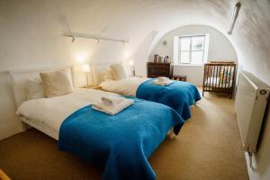 a bedroom with two beds with blue sheets at Central Courtyard Apartment in Bath