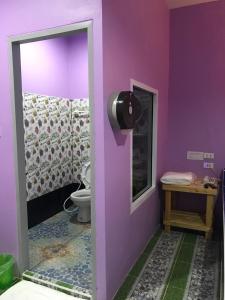 a bathroom with a toilet and a purple wall at เจิดจรัสรีสอร์ทโรงแรม24ชม in Chon Buri +32 photos