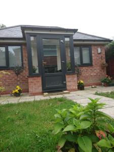 a house with a black door on a brick house at Comfortable double bedroom lovely bungalow in Manchester