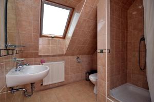 a bathroom with a sink and a toilet and a window at Dom Gościnny IRENA in Rewal