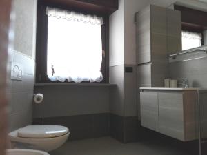 a bathroom with a toilet and a window at Appartamento Le Moulin in Aosta +12 photos