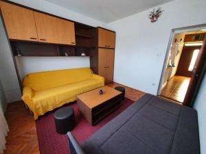a small room with a yellow bed and a table at Island Murter in Betina