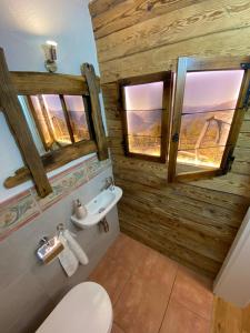 NußdorfにあるFerienwohnung Dolomitenのバスルーム(トイレ、洗面台付)、窓2つが備わります。