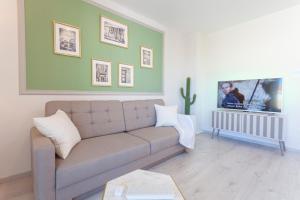 a living room with a couch and a tv at TINEL Boutique Apartment in Promajna