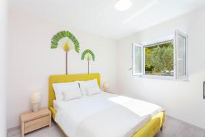 a white bedroom with a bed and a window at TINEL Boutique Apartment in Promajna
