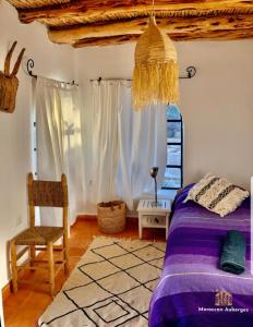 1 dormitorio con 1 cama, 1 silla y 1 ventana en DAV MAHAL Eco lodge, en Sidi Kaouki