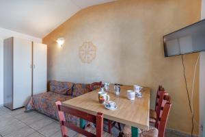 a dining room with a table and a couch at Marina Manna Hotel and Club Village in Valledoria