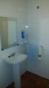 Baño blanco con lavabo y espejo en Hostal Rural Venta La Vega, en Ronda
