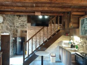 a kitchen with a staircase with a flat screen tv at panos stone tower in Páliros