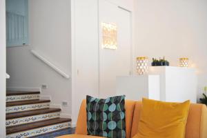 a living room with a yellow couch and stairs at Residence Panoramic in Maiori