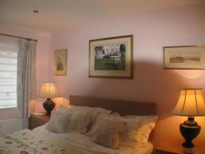 a bedroom with a bed with two lamps and two pictures on the wall at The Lantern in Donaghadee