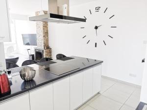 a clock hanging on a wall in a kitchen at Mackenzie Seaview Paradise in Larnaka