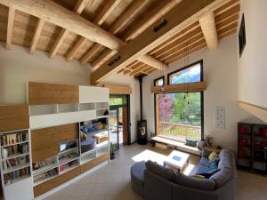 a living room with a couch and a large window at Chambres d'hôtes - B&B - Chalet Mountain Vibes in Les Houches