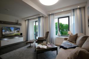 ein Wohnzimmer mit Couch und Fernseher in der Unterkunft Meersinfonie Binzprora by Rujana in Binz