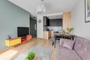 a living room and kitchen with a couch and a table at Chill Mood by Baltica Apartments in Gdańsk