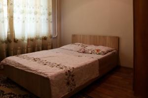 a small bed in a bedroom with a window at Apartments on Vostok 5/2 in Bishkek