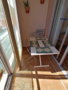 a table with a quilt on it in a room at Studio vue sur la mer au 6ème et dernier étage in Canet-en-Roussillon