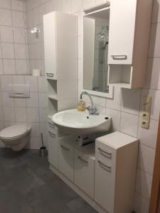 Un baño blanco con lavabo e inodoro. en Ferienwohnung Katrin, en Kelberg 3 fotos más