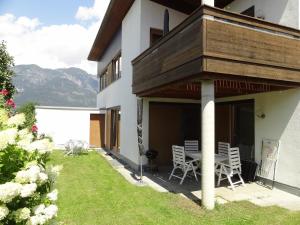 a patio with chairs and a table on the side of a building at 2-Zimmer Apartment Inntalblick in Ampass Unterdorf