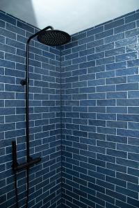 La salle de bains bleue est pourvue d'une douche et d'un mur en carrelage bleu. dans l'établissement Tukken op de Tol, à Velp