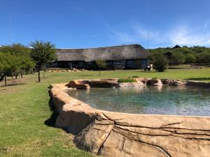 a large pool of water in front of a building at The Springbok Lodge in Nambiti Private Game Reserve