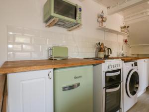 a kitchen with a counter top with a washer and dryer at Waves End in Port Isaac