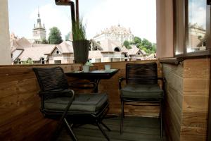 a balcony with two chairs and a table and a window at Central Boutique Apartments in Sighişoara