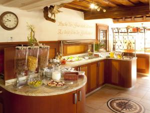 a kitchen with a counter with food and a clock at Landgasthof - Hotel zum Stern in Linden