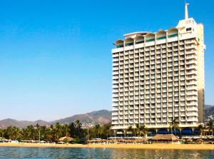 a hotel on the beach next to a body of water at Krystal Beach Acapulco in Acapulco