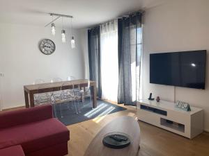 a living room with a couch and a tv and a table at Appartement Disneyland au centre du Val d'Europe in Chessy