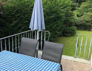 uma mesa com um guarda-sol azul e duas cadeiras e uma mesa com um azul em Ferienwohnung Sommerfeld em Bad Sassendorf